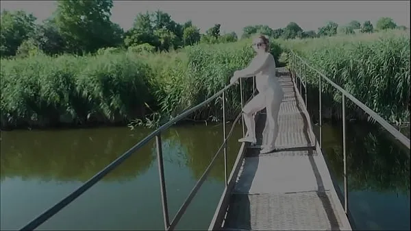 Nuovi Nostalgia estiva. Vestita di sole. Sexy donna nuda MILF cammina sul ponte sospeso del fiume. Nudisti. Naturisti. Spiaggia nudista. Clip erotica musicalefilm migliori